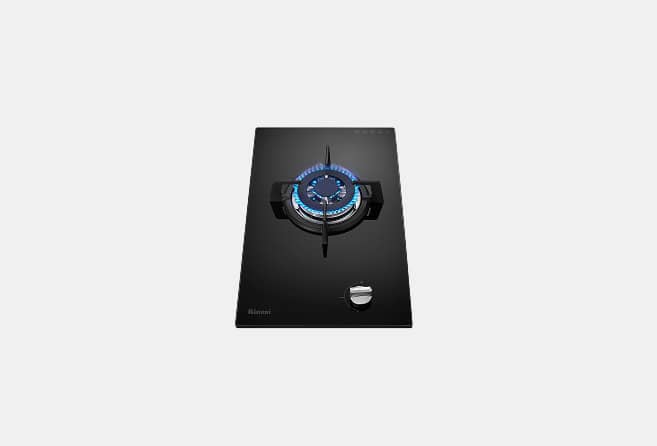 Black glass gas cooktop with a single burner lit by blue flame and a control knob nearby
