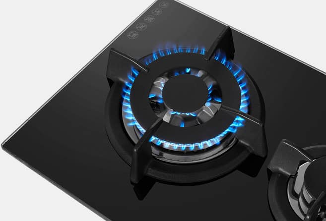 Black glass gas cooktop with two lit burners and two control knobs at the bottom.