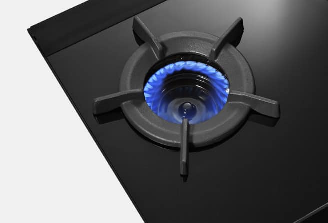Black glass gas cooktop with three burners and stainless steel control knobs in the center, blue flame lit on each burner, Rianni brand logo visible on left.