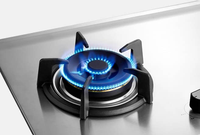 Two-burner stainless steel gas cooktop with lit blue flames and centered control knobs.