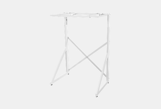 White foldable metal clothes drying rack with cross-brace supports on a light background