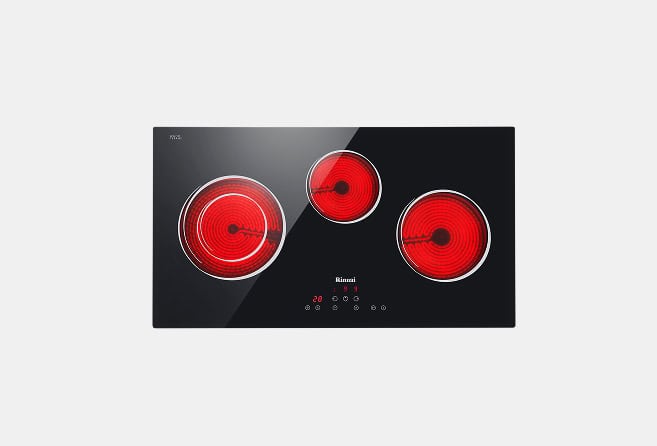 Black glass-ceramic electric cooktop with three red heated coil burners and touch controls in the center.