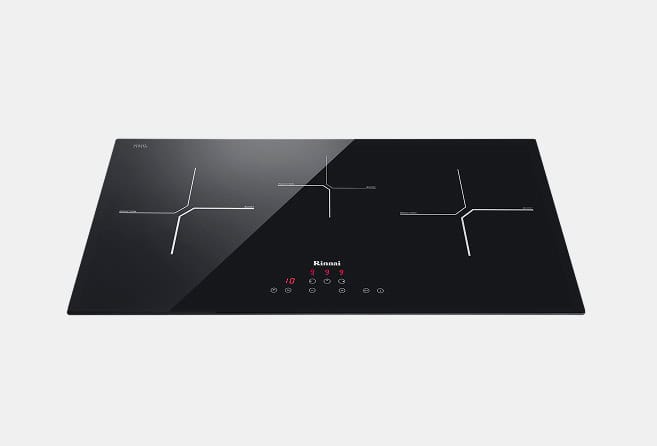 Black glass induction cooktop with three cross-shaped cooking zones, a diagonal split design, and a central touch-control panel.