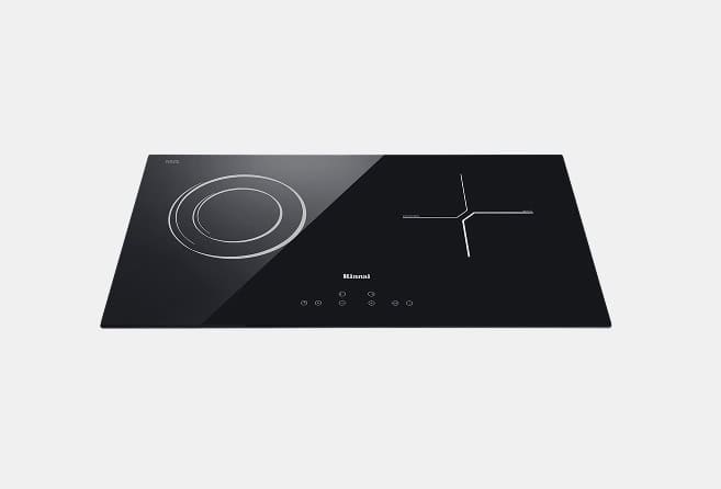 Black rectangular induction cooktop with two cooking zones: circular on the left and a cross-shaped zone on the right, touch controls in the center bottom.