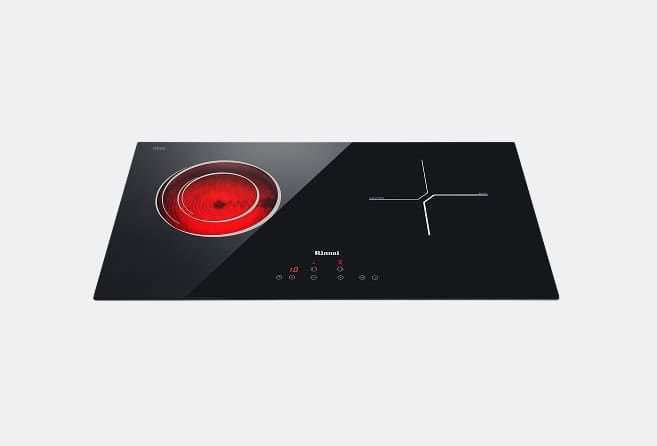 Black glass induction cooktop showing a red glowing heating ring on the left and a cross-shaped heating zone on the right set against a light background.