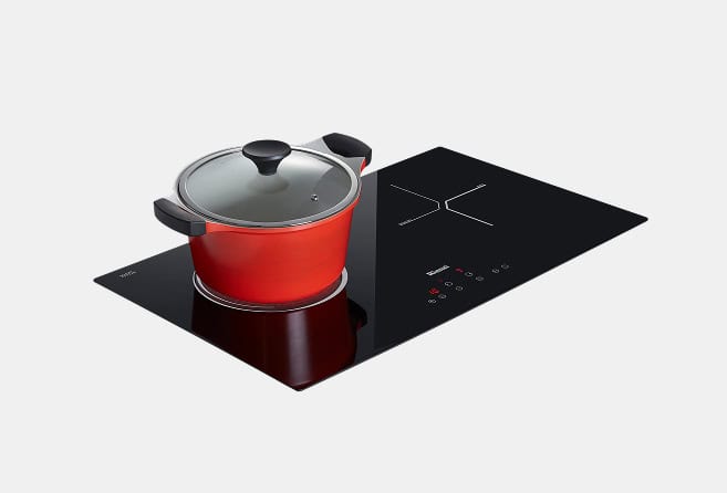 Red pot with a glass lid sits on a sleek black induction cooktop with touch controls visible on the right side.