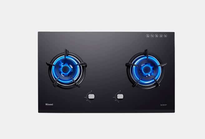 Black glass two-burner gas cooktop with blue flames and two control knobs in front (brand visible).