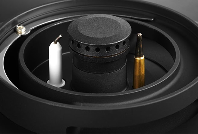 Close-up of a loudspeaker's internal components, showing the voice coil, magnet, and two terminal pins (white and gold).