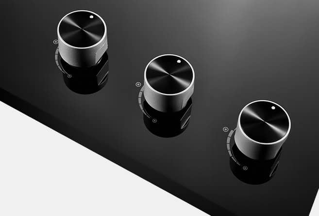Three silver rotary knobs on a dark, angled device panel.