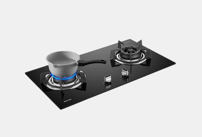 Two-burner gas cooktop with a gray pot on the left burner and a blue flame beneath it