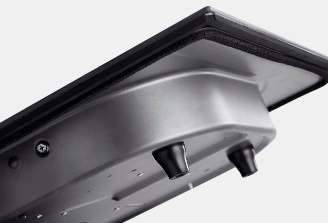 Close-up of the underside of a silver electronic device with two black control knobs visible on a curved panel.
