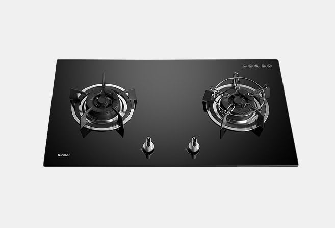Two-burner gas cooktop on a black glass surface with two front control knobs, chrome burner rings, and Rinnai branding.