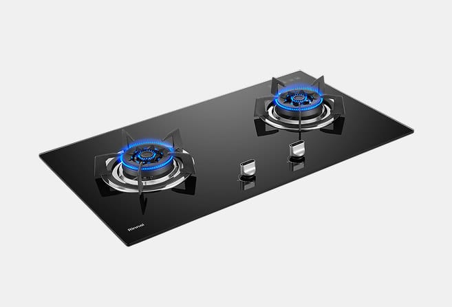 Black glass gas cooktop with two burners lit by blue flames and two control knobs on the front edge.