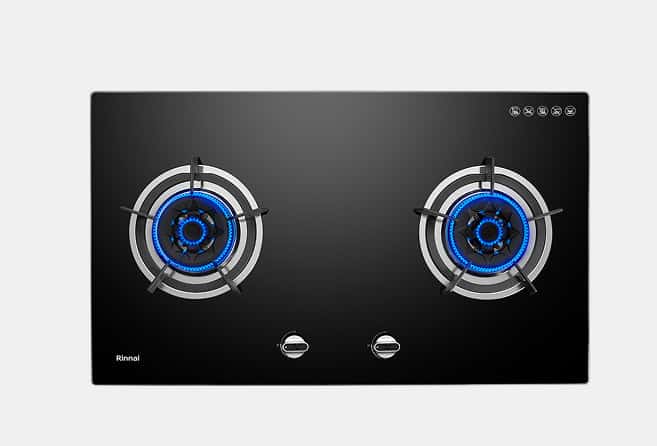 Two-burner black glass gas cooktop with blue flames, brand name Rinnai visible on left corner.