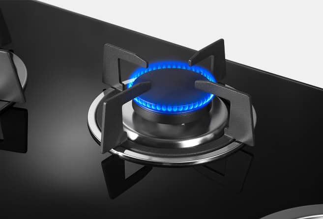 Gas stovetop burner lit with blue flame, black grate and silver burner head visible