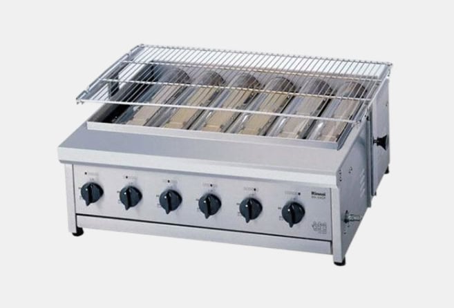 Commercial countertop toaster/grill with six control knobs and a chrome wire rack on top, used for browning bread and grilling in a café or kitchen.