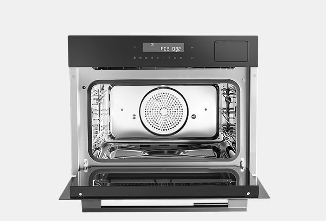 Open-front convection oven showing stainless steel interior with a perforated fan cover and digital control panel above the door.