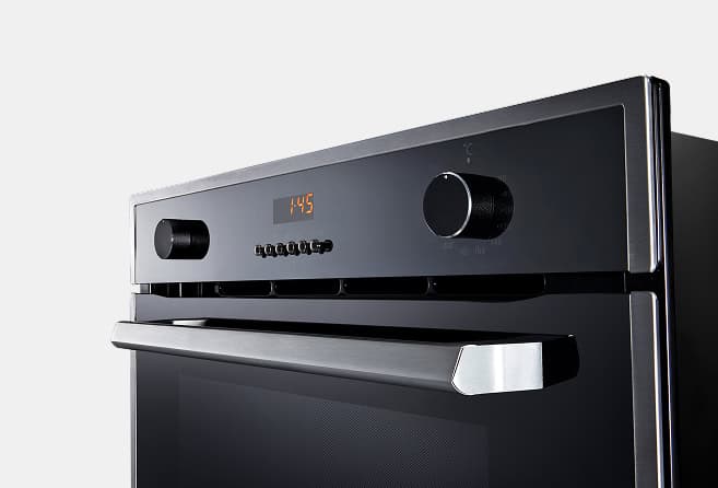 Stainless steel oven front with digital clock displaying 1:45 and control panel knobs and buttons to the left and center