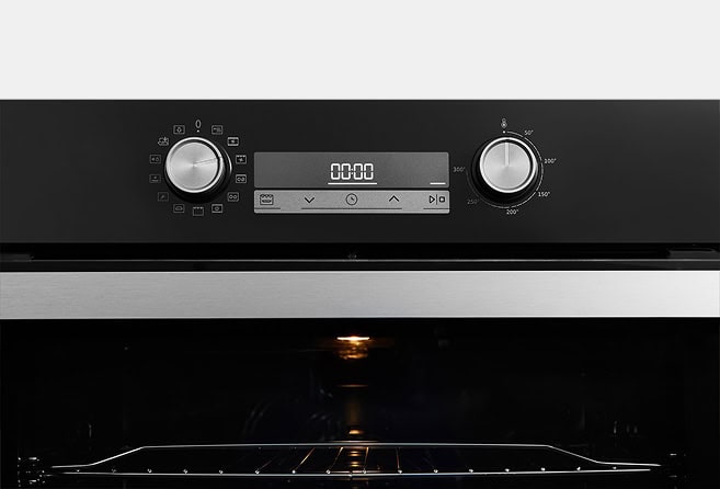 Electric oven front with digital clock reading 00:00, two control dials, and an illuminated oven cavity inside.