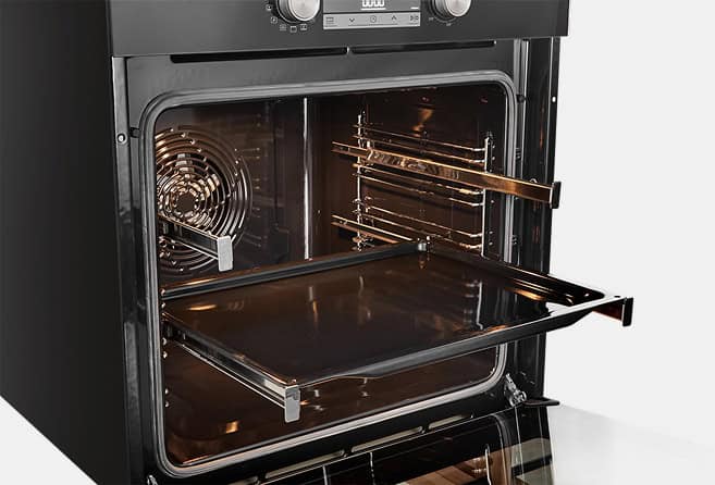 Electric oven with door open, showing multiple chrome racks inside and a fan on the left.