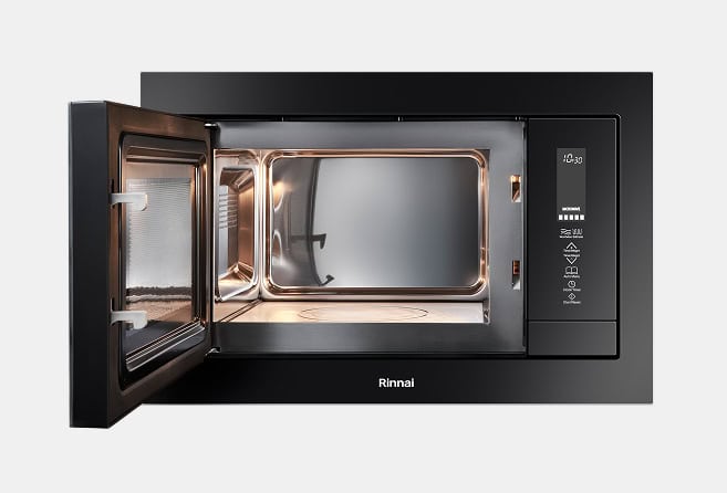 Built-in black microwave oven with door open and interior light on, showing a spacious cavity and control panel on the right (Rinnai).