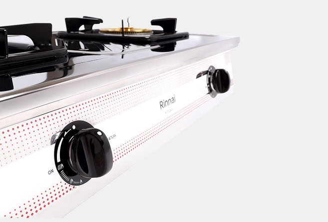 White gas cooktop with black control knobs; visible brand 'Rinnai' and burner grate on top.