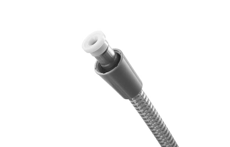 Close-up of a stainless steel braided hose with a white plastic connector at the end.
