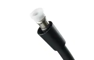 Close-up of a black plastic electrical connector with a white ceramic insulator and metal pin.