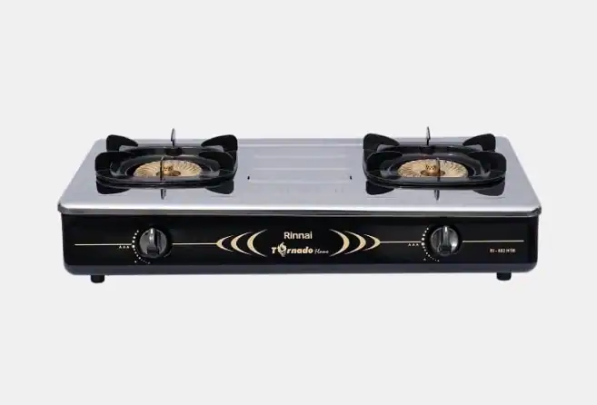 Two-burner stainless steel gas stove with a black front panel and brass burner heads on a countertop surface